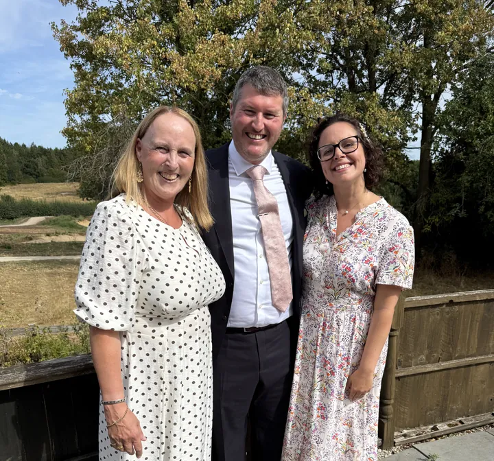 Wedding moment 3: Lesley Coles with a smiling couple outdoors